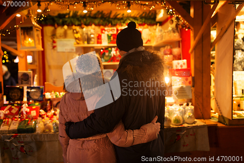 Image of happy senior couple hugging at christmas market