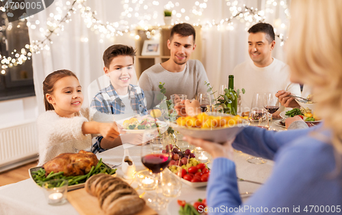 Image of happy family having dinner party at home