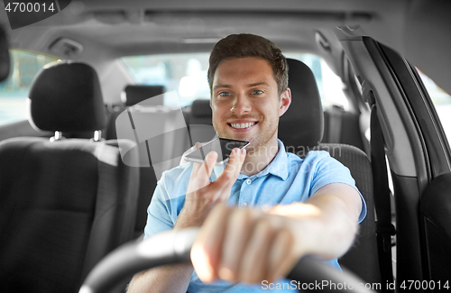 Image of man driving car and recording voice by smartphone