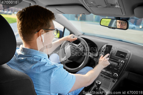 Image of man driving car and using gps on smartphone