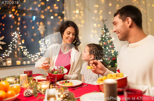 Image of happy family having christmas dinner at home