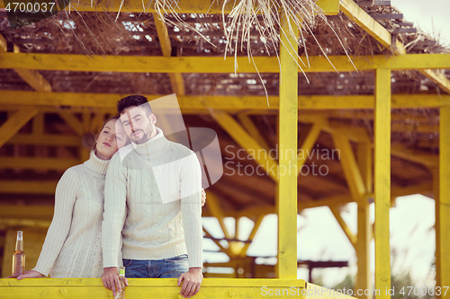 Image of young couple drinking beer together at the beach