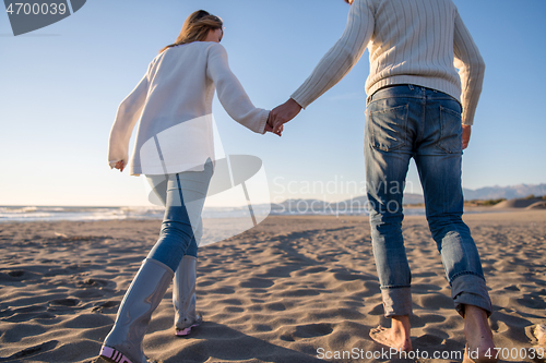 Image of Loving young couple on a beach at autumn sunny day