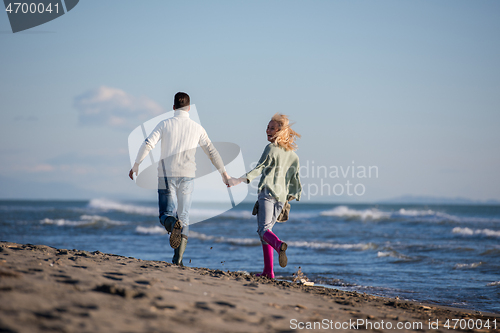 Image of Loving young couple on a beach at autumn sunny day