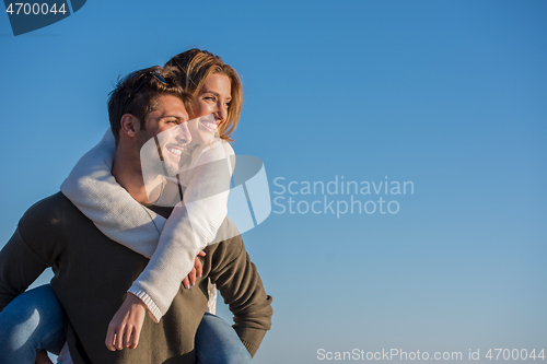 Image of couple having fun at beach during autumn