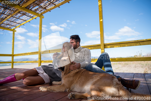 Image of Couple with dog enjoying time on beach