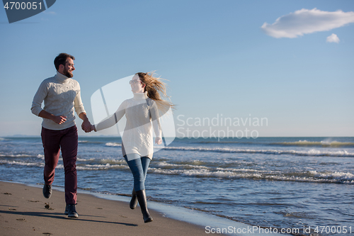 Image of Loving young couple on a beach at autumn sunny day