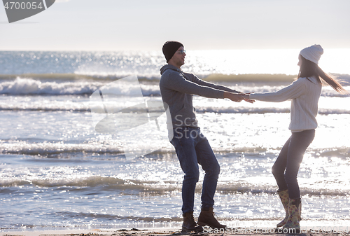 Image of Loving young couple on a beach at autumn sunny day