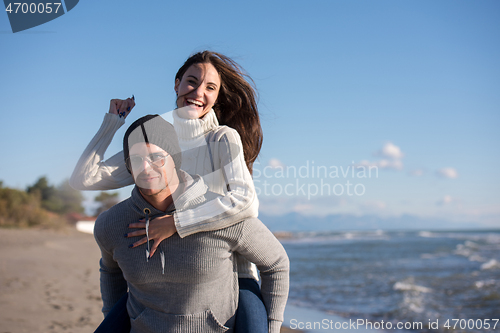 Image of couple having fun at beach during autumn