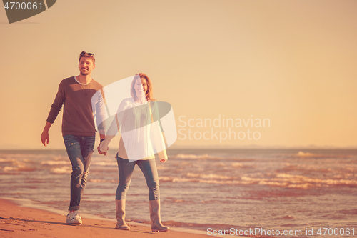 Image of Loving young couple on a beach at autumn sunny day