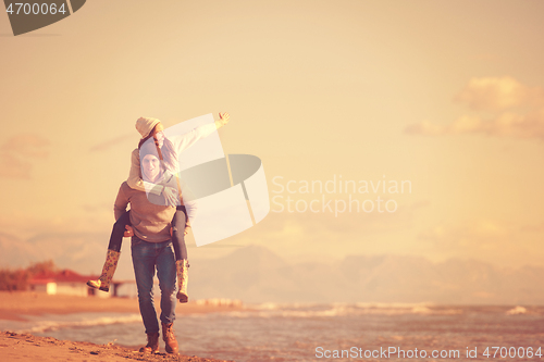 Image of couple having fun at beach during autumn