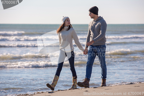 Image of Loving young couple on a beach at autumn sunny day