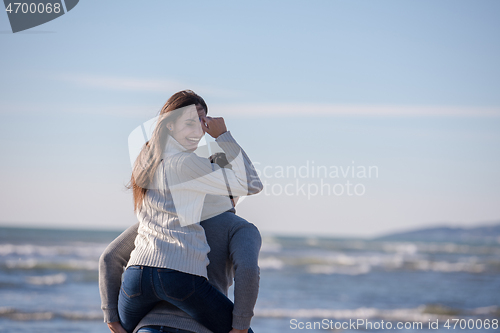 Image of couple having fun at beach during autumn