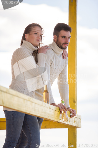 Image of young couple drinking beer together at the beach