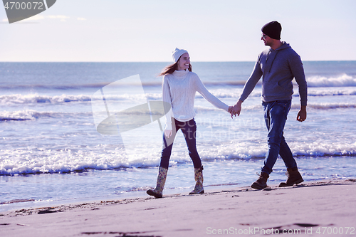 Image of Loving young couple on a beach at autumn sunny day