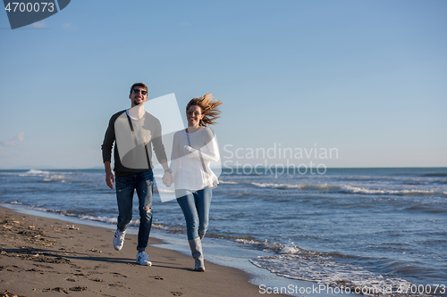 Image of Loving young couple on a beach at autumn sunny day