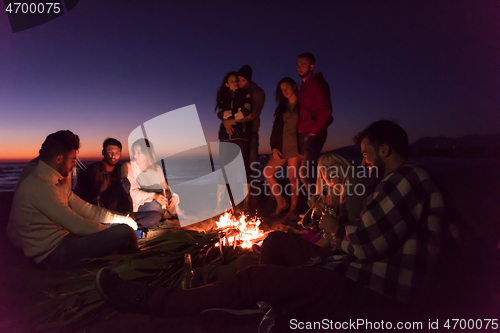 Image of Friends having fun at beach on autumn day