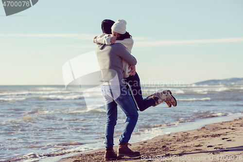 Image of Loving young couple on a beach at autumn sunny day