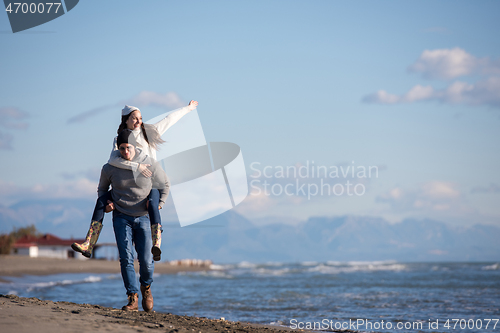 Image of couple having fun at beach during autumn