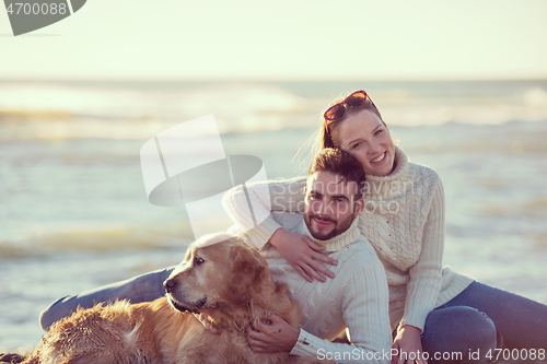 Image of Couple with dog enjoying time on beach