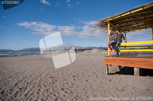 Image of young couple drinking beer together at the beach