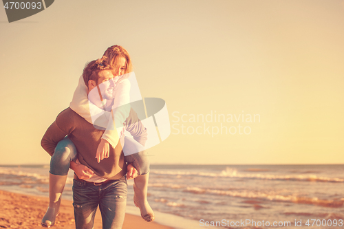 Image of couple having fun at beach during autumn