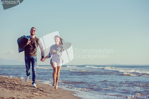 Image of Loving young couple on a beach at autumn sunny day