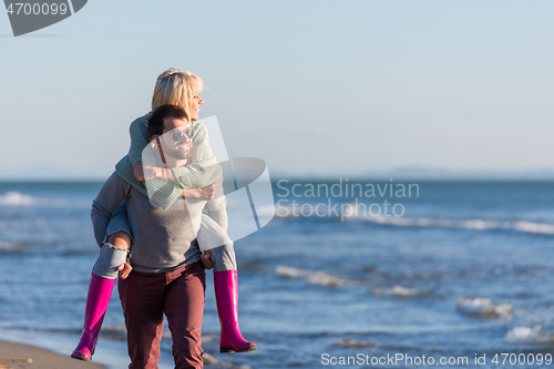 Image of couple having fun at beach during autumn