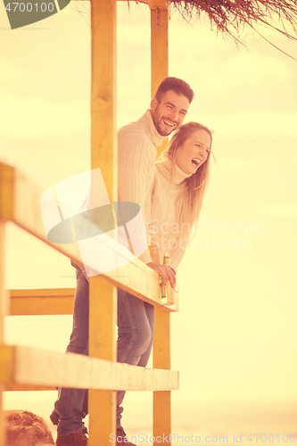 Image of young couple drinking beer together at the beach