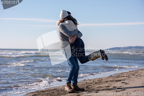 Image of Loving young couple on a beach at autumn sunny day