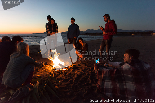 Image of Friends having fun at beach on autumn day