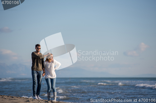 Image of Loving young couple on a beach at autumn sunny day