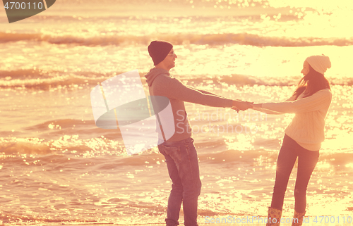 Image of Loving young couple on a beach at autumn sunny day