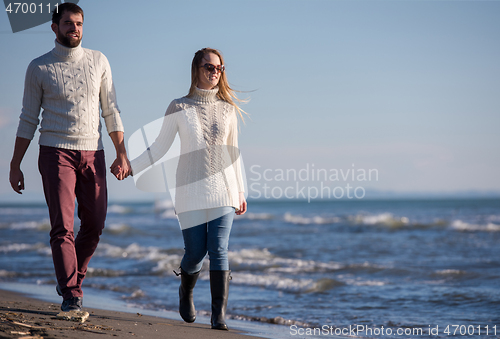 Image of Loving young couple on a beach at autumn sunny day