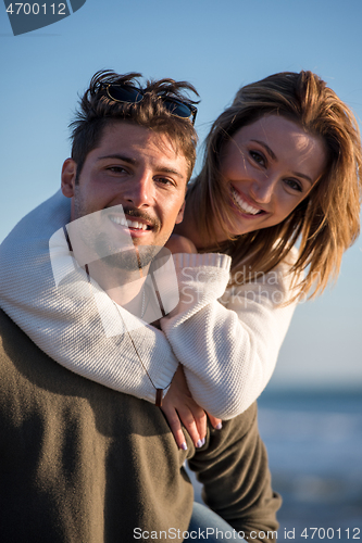 Image of couple having fun at beach during autumn