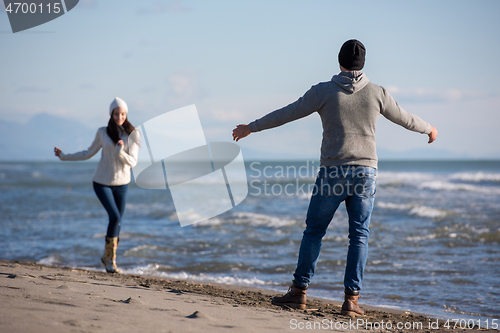 Image of Loving young couple on a beach at autumn sunny day