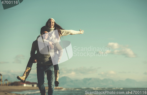 Image of couple having fun at beach during autumn