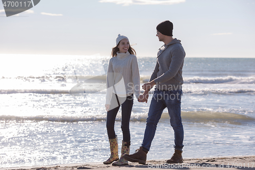 Image of Loving young couple on a beach at autumn sunny day