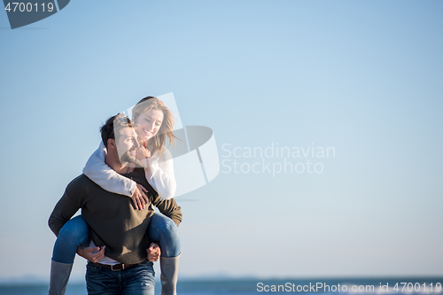 Image of couple having fun at beach during autumn