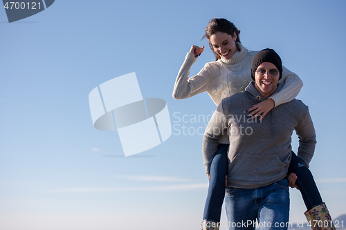 Image of couple having fun at beach during autumn