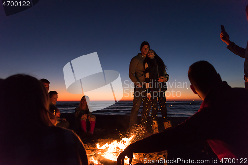 Image of Friends having fun at beach on autumn day