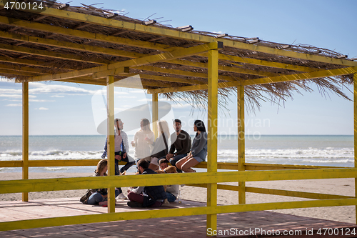 Image of Group of friends having fun on autumn day at beach