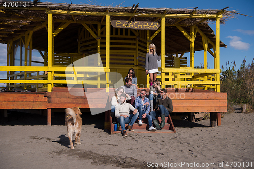 Image of Group of friends having fun on autumn day at beach