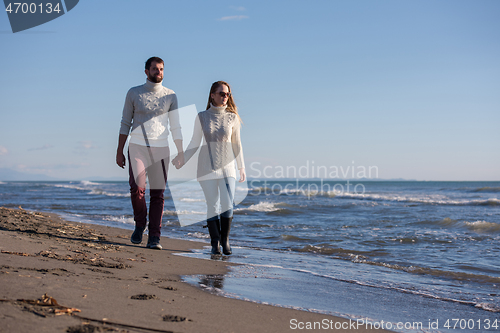 Image of Loving young couple on a beach at autumn sunny day