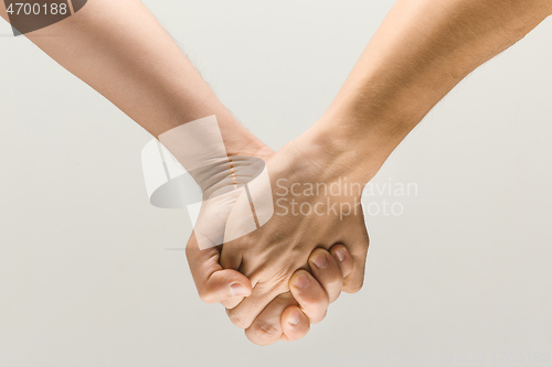 Image of  loseup shot of male holding hands isolated on grey studio background.
