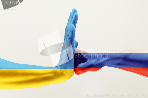 Image of Two hands. Flag of Russian Federation. Flag of Ukraine.