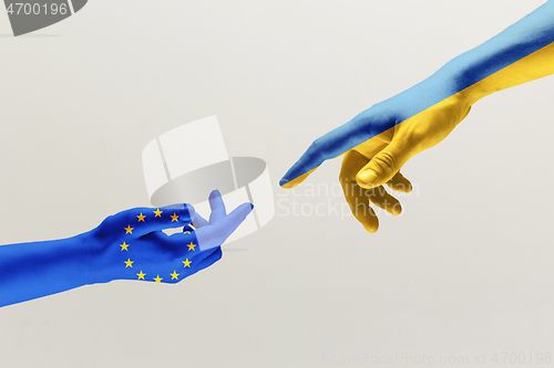 Image of Two hands. Flag of the European Union. Flag of Ukraine.