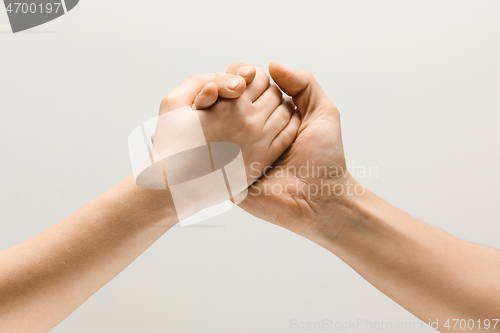 Image of Two male hands competion in arm wrestling isolated on grey studio background