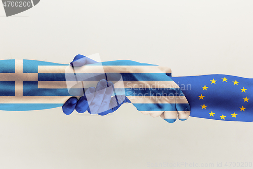 Image of Male hands holding colored in blue EU and Greece flag