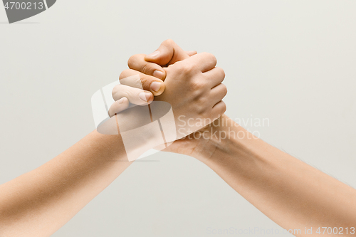 Image of Two male hands competion in arm wrestling isolated on grey studio background